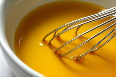 Image showing natural oils being carefully mixed in a bowl, highlighting the liquids and colors