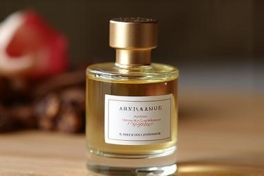 A small, elegant bottle of artisanal natural perfume on a wooden surface